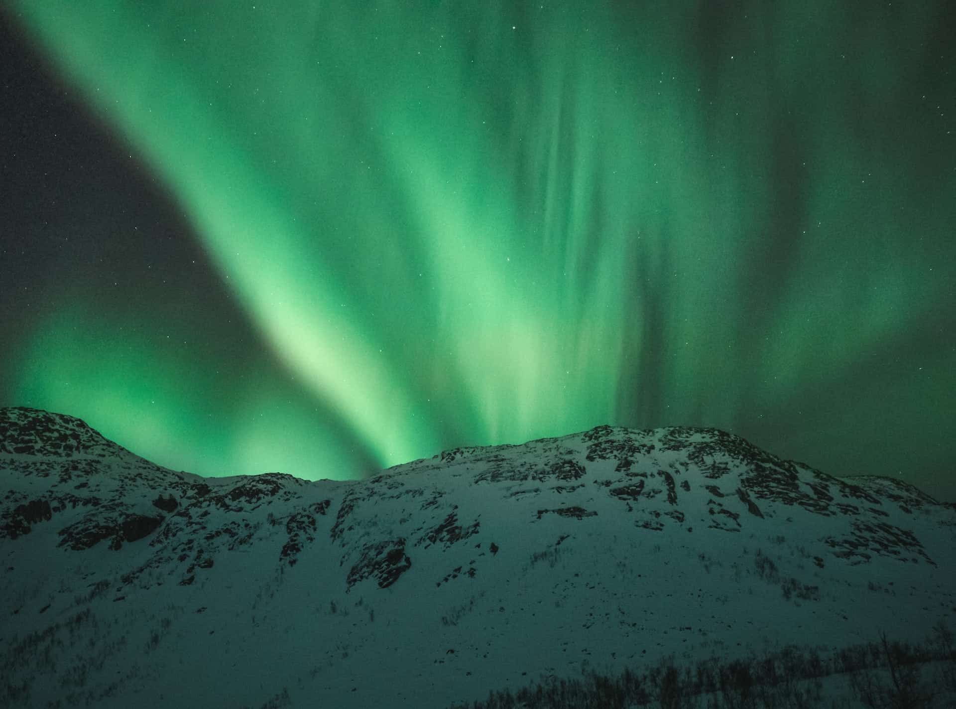 Snø på et fjell under nordlys