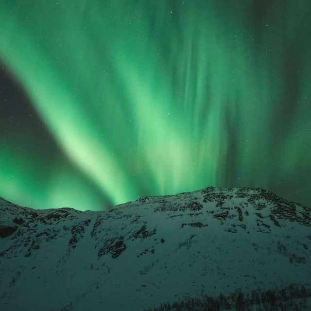 Snø på et fjell under nordlys